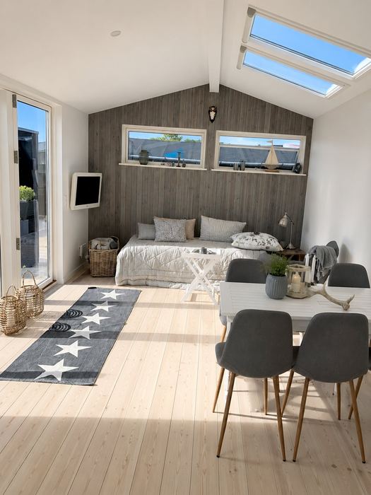 Lyst opholdsrum med Velux ovenlys og seng — Pergolahuset