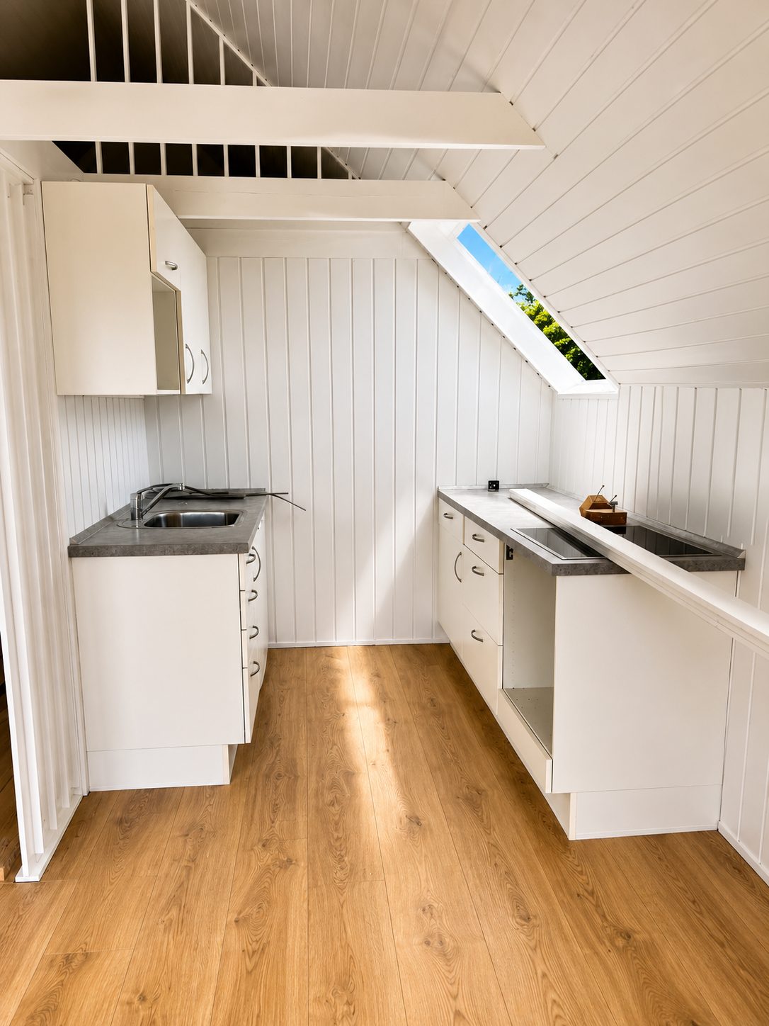 Hvidt køkken under skråt loft med ovenlysvindue — A-huset