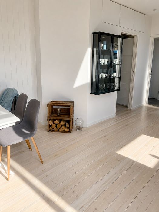 Stue med lyst gulv og gennemsigtighed til gang — Pergolahuset