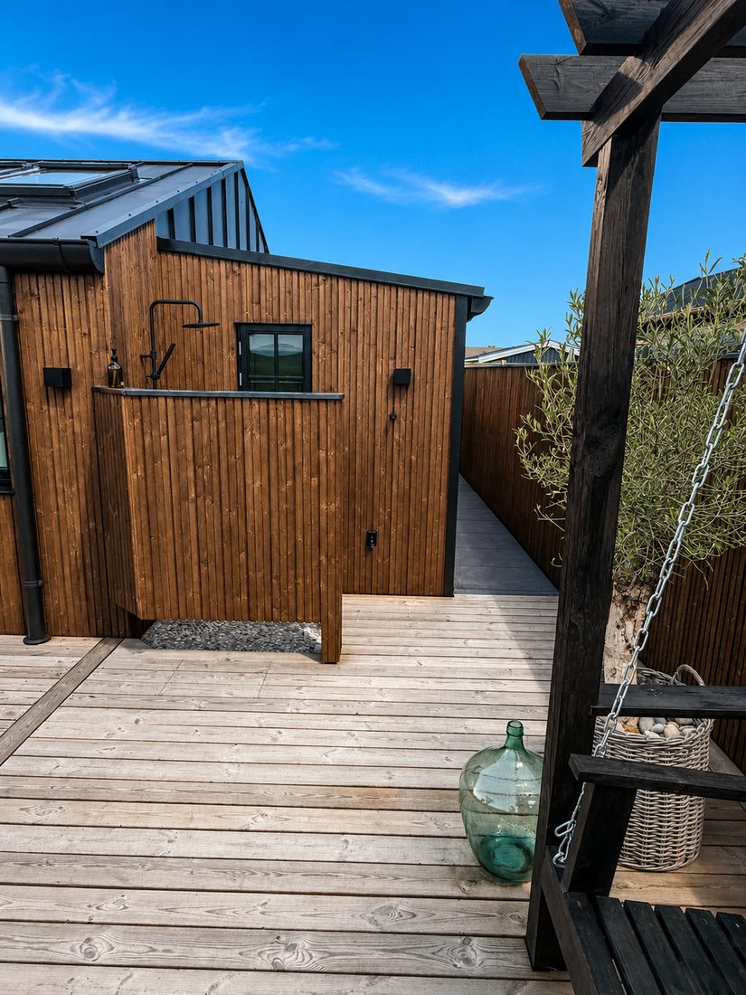 Udendørs bruser i træ og overdækket terrasse med pergola — Havehuset