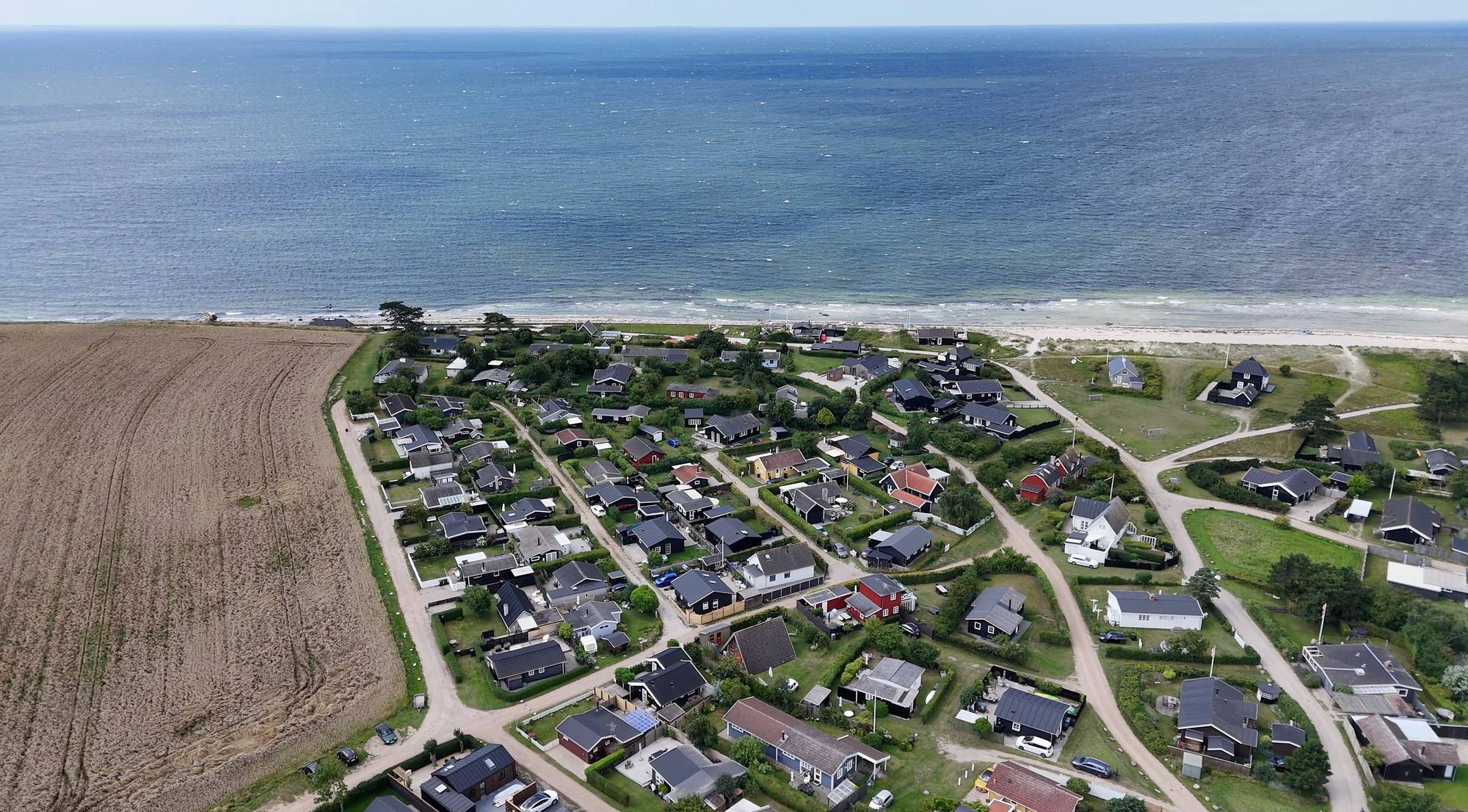 Luftfoto over sommerhusområde på Enø med huse ned til stranden og havet