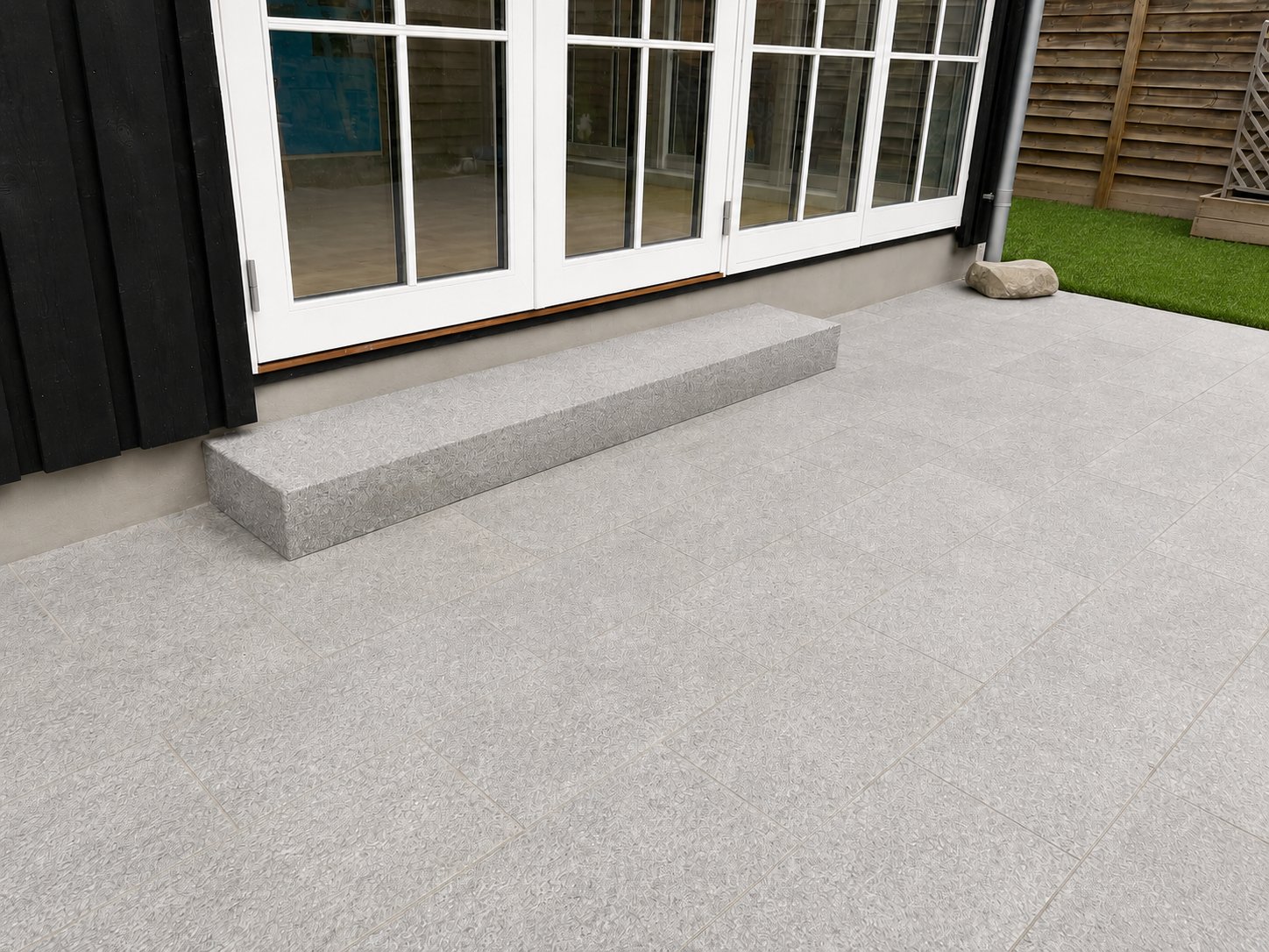 Granit trappetrin og fliseterrasse langs sort facade med hvide sprossevinduer — Faxe Ladeplads