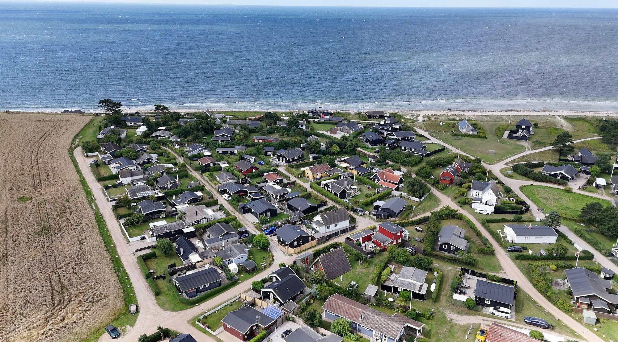 Luftfoto over sommerhusområde ved Karrebæksminde med huse ned til stranden og havet